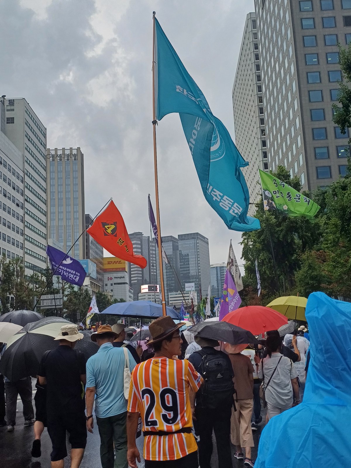 빗속의 행진, 대열 위로 휘날리는 하늘색 외민동 깃발